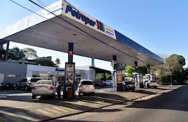 Dos personas en la estación de servicio Petropar, una junto a un automóvil y otra supervisando el proceso de carga de combustible.