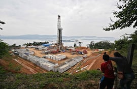 Una mujer y unos niños observan el yacimiento de gas natural Mayaya Centro-X1, perteneciente a la empresa estatal boliviana Yacimientos Petrolíferos Fiscales Bolivianos (YPFB), en Alto Beni, provincia de Caranavi (Bolivia)