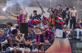 Los jugadores del FC Barcelona, el brasileño Raphinha (i) y el francés, Jules Koundés, durante la celebración este viernes de la consecución del triplete nacional (Supercopa de España, Copa del Rey y LaLiga conquistada el jueves) con unas rúas por las calles de la capital catalana.
