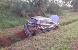 SUV dañado en la zanja, rodeado de vegetación alta. No hay personas visibles en la escena.