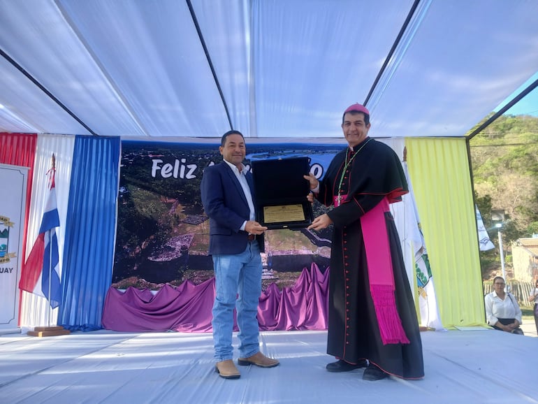El obispo Gabriel Escobar recibe una placa recordatoria de parte del intendente