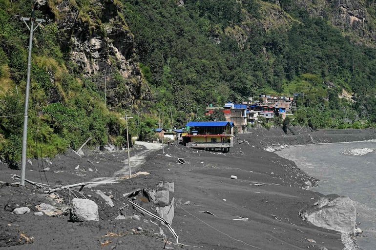 Viviendas dañadas y parcialmente sumergidas en el lodo yacen a orillas del río Budhi Gandaki, en Soti Bazar, distrito de Gorkha, Nepal, el 14 de octubre de 2026, tras una inundación repentina provocada por un deslizamiento de tierra en seco.