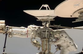 Esta captura de pantalla, tomada el 18 de agosto de 2026 de una transmisión en vivo de la NASA, muestra al astronauta de la NASA Anil Menon (izq.) y a la astronauta de la ESA Sophie Adenot (der.) trabajando durante una caminata espacial en el exterior de la Estación Espacial Internacional (ISS), con el objetivo de reemplazar una antena de comunicación entre el espacio y la Tierra, según informó la NASA.