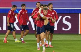 Los jugadores del Olympiacos durante el entrenamiento del equipo celebrado este lunes en el estadio Olímpico Lluis Companys, en Montjuic, para preparar el partido correspondiente a la tercera jornada de la fase liga de la Liga de Campeones, que disputarán mañana en dicho Estadio ante el FC Barcelona.