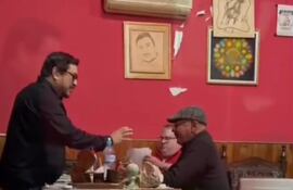 El intendente Gustavo Penayo Arce (de pie) aparece entregando dinero al concejal Rubén Pedrozo, supuestamente como un cobro adicional a cambio de elogiar su obra.