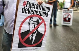 Personas sostienen carteles con la imagen del presidente de Estados Unidos, Donald Trump, durante una marcha contra el acuerdo petrolero entre Venezuela y Estados Unidos este jueves, en Caracas