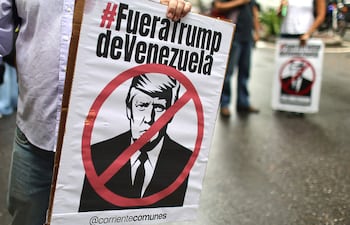 Personas sostienen carteles con la imagen del presidente de Estados Unidos, Donald Trump, durante una marcha contra el acuerdo petrolero entre Venezuela y Estados Unidos este jueves, en Caracas