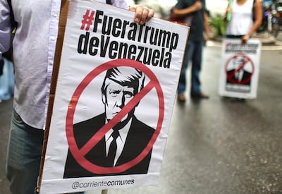 Personas sostienen carteles con la imagen del presidente de Estados Unidos, Donald Trump, durante una marcha contra el acuerdo petrolero entre Venezuela y Estados Unidos este jueves, en Caracas