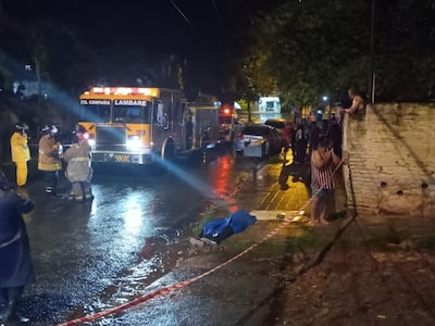 El cuerpo, ya sin vida, de Deisy Paola Giménez es observado por los bomberos y los vecinos.