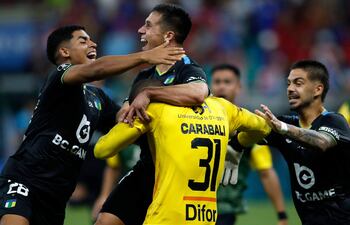 El portero de O'Higgins Omar Carabalí, celebra con sus compañeros al finalizar la tanda de penaltis del partido de vuelta de la segunda fase de la Copa Libertadores entre el Bahía de Brasil y el O'Higgins de Chile, en el estadio Arena Fonte Nova en Salvador, Brasil.