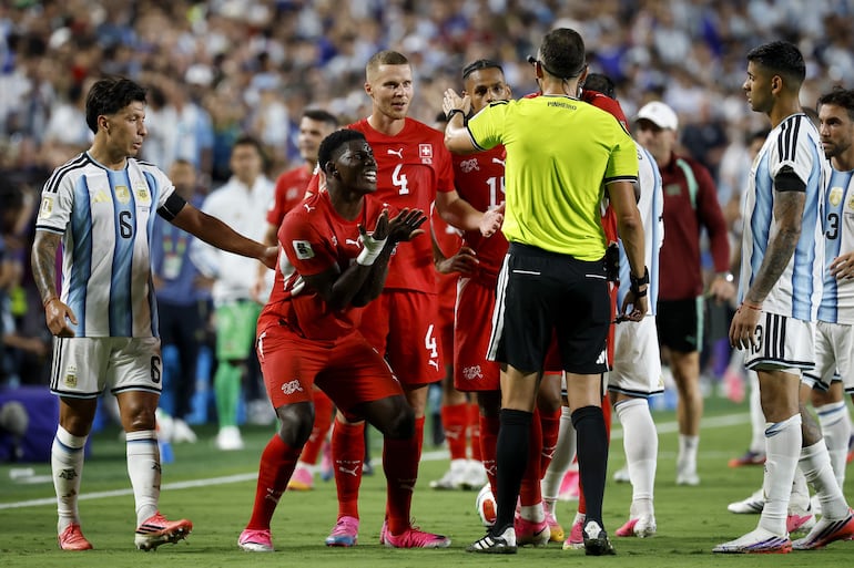 Breel Embolo de Suiza (I) reacciona luego de que el árbitro Joao Pinheiro (D) le mostrara una tarjeta roja tras la intervención del VAR durante el partido de cuartos de final de la Copa Mundial de la FIFA 2026 entre Argentina y Suiza, en Kansas City, Misuri, EE. UU..