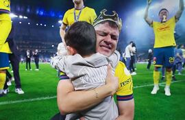 El paraguayo Richard Sánchez, futbolista del América, celebra con su hijo la conquista del torneo Apertura 2024 de la LigaMX en el estadio BBVA, en Guadalupe, Nueva León.