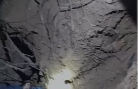 Un policía paraguayo remueve la tierra con una pala para desenterrar los restos de la mujer.