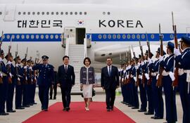 FotografÍa cedida por el ministerio de Relaciones Exteriores de Chile de su ministro, Francisco Pérez Mackenna (d), caminando junto al presidente de la República de Corea, Lee Jae Myung (c-i) y su esposa Kim Hea Kyung (c), este miércoles, a su llegada al Aeropuerto Arturo Merino Benítez, en Santiago (Chile).