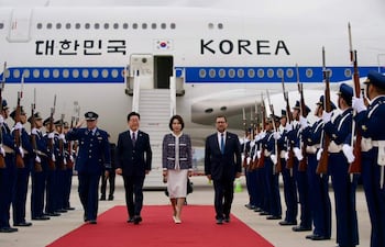 FotografÍa cedida por el ministerio de Relaciones Exteriores de Chile de su ministro, Francisco Pérez Mackenna (d), caminando junto al presidente de la República de Corea, Lee Jae Myung (c-i) y su esposa Kim Hea Kyung (c), este miércoles, a su llegada al Aeropuerto Arturo Merino Benítez, en Santiago (Chile).