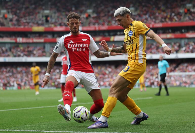 El paraguayo Julio Enciso (d), jugador del Brighton, pelea por el balón en el partido frente al Arsenal por la tercera fecha de la Premier League en el Emirates Stadium, en Londres, Inglaterra.