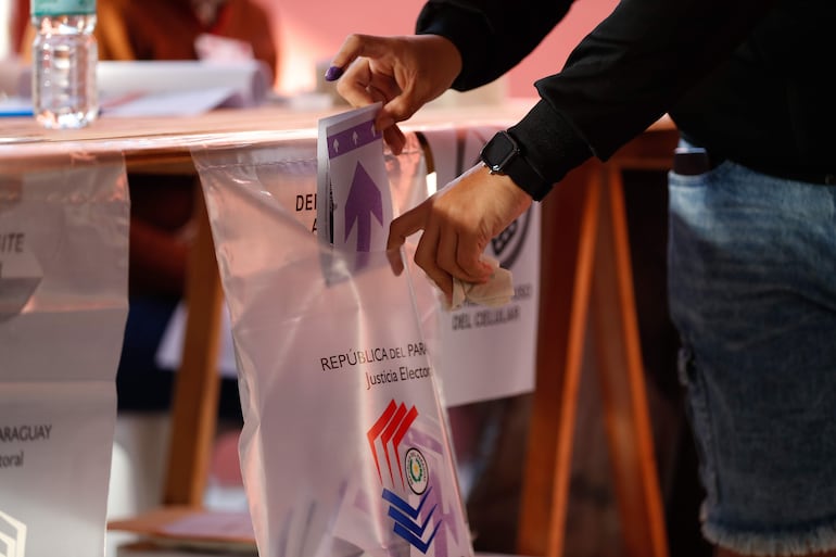 Una persona deposita su voto durante la jornada de elecciones primarias en Asunción.