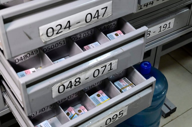 Cajones grises organizadores en oficina, cada uno con etiquetas numéricas y documentos visibles.