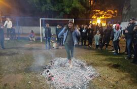 Tatá ári jehasa: una mujer descalza desafía a los carbones ardientes en el San Juan del Club Emiliano R. Fernández, del barrio Villa Aurelia de Asunción, en el año 2022.