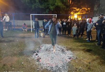 Tatá ári jehasa: una mujer descalza desafía a los carbones ardientes en el San Juan del Club Emiliano R. Fernández, del barrio Villa Aurelia de Asunción, en el año 2022.