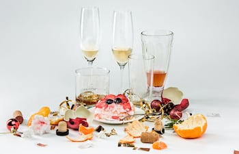 Restos de alcohol y comida en una mesa de navidad.