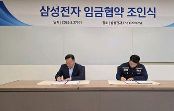 Fotografía cedida por la Delegación negociadora conjunta del sindicato de Samsung Electronics que muestra al jefe del equipo de recursos humanos de la división de soluciones para dispositivos (DS) de Samsung Electronics, Yeo Myeong-gu (i), y al jefe del principal sindicato del fabricante de chips, Choi Seung-ho, firmando el acuerdo salarial que detuvo una huelga masiva en el fabricante de chips surcoreano.