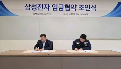 Fotografía cedida por la Delegación negociadora conjunta del sindicato de Samsung Electronics que muestra al jefe del equipo de recursos humanos de la división de soluciones para dispositivos (DS) de Samsung Electronics, Yeo Myeong-gu (i), y al jefe del principal sindicato del fabricante de chips, Choi Seung-ho, firmando el acuerdo salarial que detuvo una huelga masiva en el fabricante de chips surcoreano.