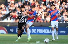 El argentino Alexander Barboza (i), jugador de Libertad, pelea por el balón en el partido contra Cerro Porteño por la ronda 19 del torneo Clausura 2023 del fútbol paraguayo.