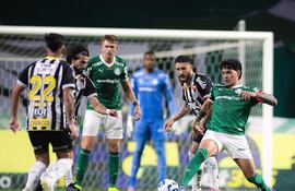 El zaguero paraguayo, capitán de Palmeiras, Gustavo Gómez Portillo se anticipa al volante ofensivo del Santos Zé Rafael.