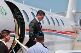 Presidente Santiago Peña baja de un avión luego de uno de sus viajes al exterior.