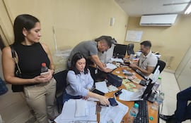 La fiscala Verónica Valdez (de camisilla negra) observando el conteo de los billetes, en distintas monedas, y la elaboración del acta de procedimiento.