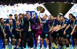 El delantero argentino del Inter de Milán, Lautaro Martínez, levanta el trofeo junto al entrenador rumano del Inter de Milán, Cristian Chivu, para celebrar con sus compañeros su 21º scudetto (victoria en el Campeonato Italiano) en el estadio de San Siro tras el partido de fútbol de la Serie A italiana entre el Inter de Milán y el Hellas Verona en Milán.