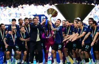 El delantero argentino del Inter de Milán, Lautaro Martínez, levanta el trofeo junto al entrenador rumano del Inter de Milán, Cristian Chivu, para celebrar con sus compañeros su 21º scudetto (victoria en el Campeonato Italiano) en el estadio de San Siro tras el partido de fútbol de la Serie A italiana entre el Inter de Milán y el Hellas Verona en Milán.