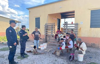 Dos oficiales de policía conversan con hombres y mujeres de la comunidad Tomarahos.