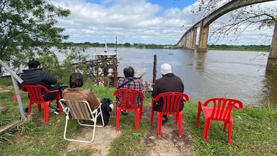 Familiares del camionero caído en aguas del río Paraguay, desde el puente Nanawa, observan los trabajos de la Prefectura Naval este martes. Todavía no se pudo rescatar el cuerpo del chofer, que se encuentra a 12 metros de profundidad, dentro de su camión.