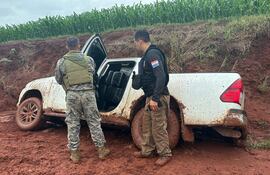 Agentes, tanto de la Senad como de la Policía verifican el interior de la camioneta que quedó huida en el barro.