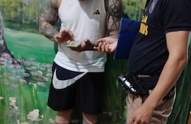 Alexis Vidal González Zárate, alias Pelado, entrega su celular a un policía, en la cárcel de Emboscada.