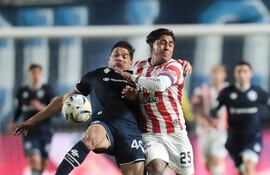 El defensor paraguayo de Independiente Rivadavia, Iván Villalba va a la disputa por el esférico con el atacante de Unión de Santa Fe, Cristian Tarragona