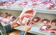 Paquetes de carne envasada, dispuesta para la venta en el refrigerador de un supermercado.