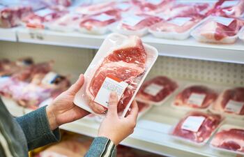 Paquetes de carne envasada, dispuesta para la venta en el refrigerador de un supermercado.