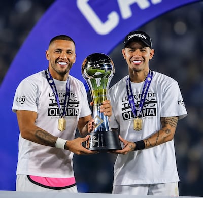Richard Ortiz y Derlis González, principales referentes del plantel de Olimpia, con el trofeo de la Copa Paraguay conquistado por los franjeados en 2021.