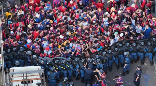 Aficionados de Cerro Porteño fuerzan la barrera policial durante el Clásico contra Olimpia en Asunción.