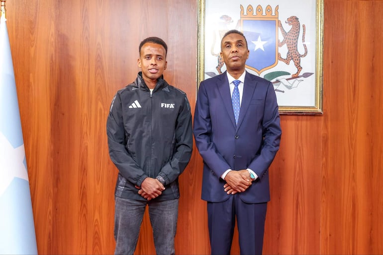 El árbitro somalí Omar Abdulkadir Artan (i), cuya entrada a Estados Unidos fue denegada la semana pasada cuando iba a participar en el Mundial de fútbol, fue recibido este miércoles por el primer ministro somalí, Hamza Abdi Barre.