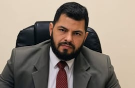 Cristhian Sánchez con traje oscuro y corbata, sentado en su oficina, mira a la cámara con expresión tranquila.