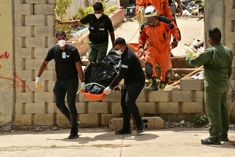 Equipos de rescate transportan un cadáver recuperado de entre los escombros en Playa Grande, Catia La Mar (estado de La Guaira, Venezuela)