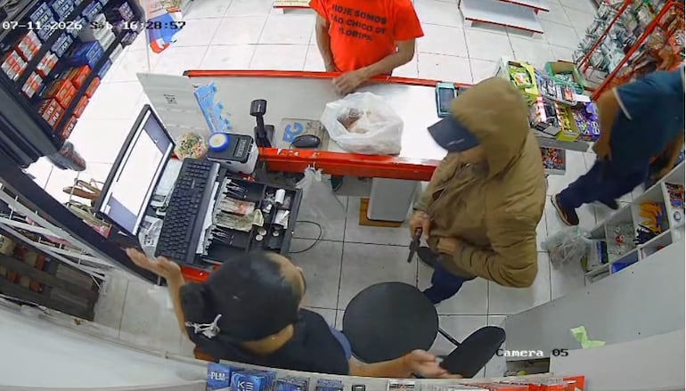 El otro sospechoso se encarga de vaciar la caja registradora, también estaba armado con un revólver. 