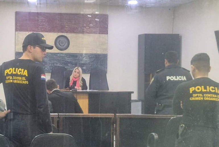 Jueza Rosarito Montanía, mujer con cabello largo y blusa negra, escucha a oficiales de policía en ambiente judicial.