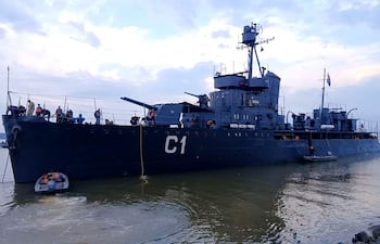 Buque Cañonero Paraguay C-1 en el puerto, con personas en chalecos de seguridad en cubierta y un bote auxiliar cerca.