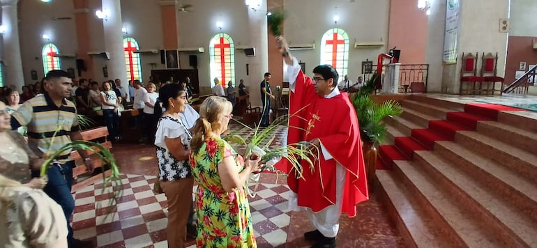 El sacerdote José Echeverría, bendice las palmas al término de la misa dentro de la Basílica Menor Nuestra Señora del Pilar.