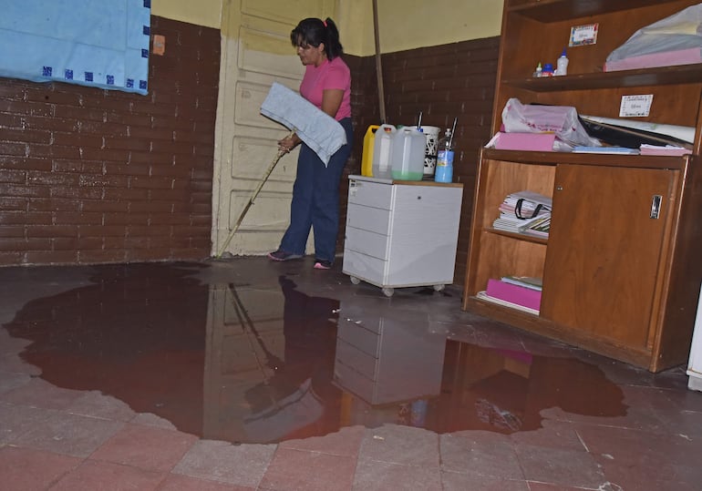 La profesora Nancy Medina muestra parte del piso inundado en el primer grado.